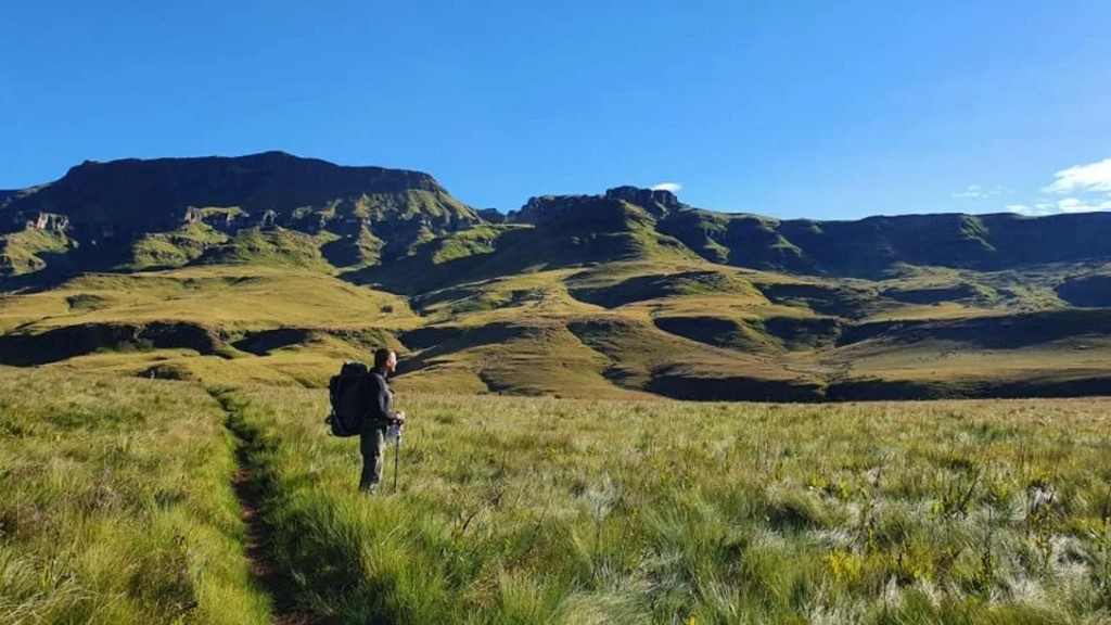 Hiker on the Giants Cup Trail below the Drakensberg escarpment, South Africa